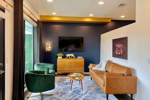a living room with a couch and a tv at CHIC Modern Nashville Condo POOL, PATIO, PARKING in Nashville