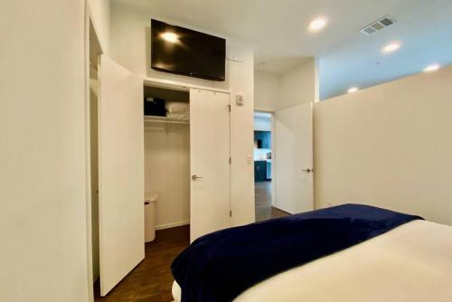 a bedroom with a bed and a tv on a wall at CHIC Modern Nashville Condo POOL, PATIO, PARKING in Nashville