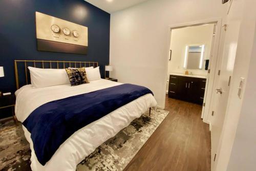 a bedroom with a large bed with a blue wall at CHIC Modern Nashville Condo POOL, PATIO, PARKING in Nashville