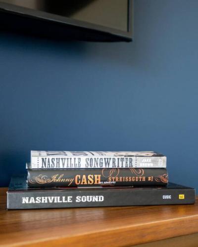 a stack of three books sitting on a table at CHIC Modern Nashville Condo POOL, PATIO, PARKING in Nashville
