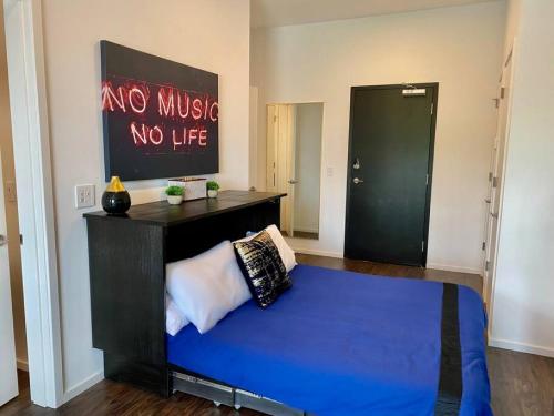 a bedroom with a blue bed with a no music no life sign at CHIC Modern Nashville Condo POOL, PATIO, PARKING in Nashville
