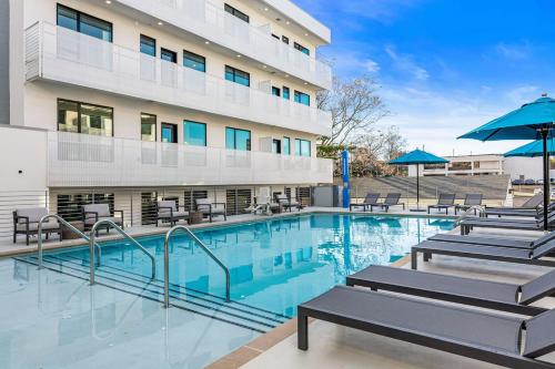 a swimming pool with chairs and a building at CHIC Modern Nashville Condo POOL, PATIO, PARKING in Nashville