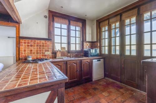 une cuisine avec des armoires en bois et un comptoir dans l'établissement Maison Mahu - Welkeys, à Villerville