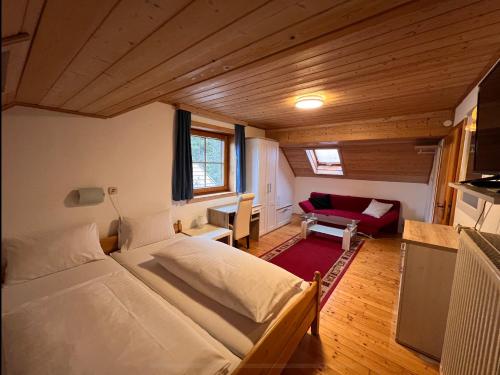 a bedroom with a large bed and a red couch at Panoramahaus Steiner in Mariapfarr