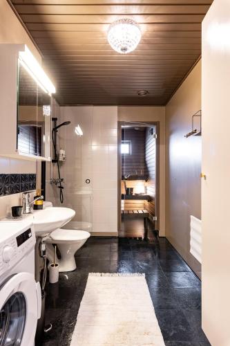 a bathroom with a sink and a washing machine at Cozy Room x Aurora Lights in Tampere