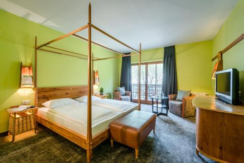 a bedroom with a four poster bed and a television at Botango in Parcines