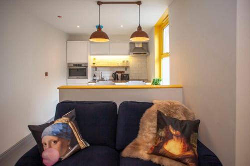 ein Wohnzimmer mit einem blauen Sofa und 2 Kissen in der Unterkunft higgihaus Apartment 4 Clare Street Aparthotel Central Location in Bristol