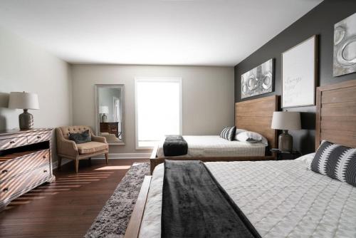 a bedroom with two beds and a chair at CONDO ON MUSIC ROW w PARKING, SLEEPS 6, POOL in Nashville