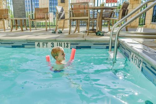 a young boy playing in a swimming pool at Hyatt House Santa Clara in Santa Clara