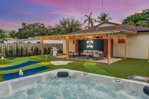 a backyard with a hot tub in the yard at Sea-renity Villa: game room, cornhole, beach, 3 miles from FLL Airport in Fort Lauderdale