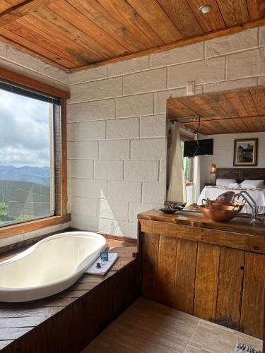 a large bathroom with a tub and a sink at Pousada do Rei Arthur in Lavras Novas