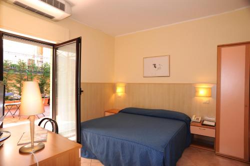 a hotel room with a bed and a sliding glass door at Villa Santacroce in San Giovanni Rotondo