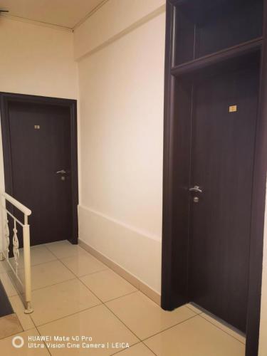 a hallway with two black doors and a staircase at Lovely Bosnian Home in Mostar