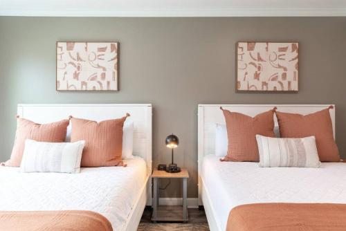 two beds with white and orange pillows in a room at Downtown Nashville Condo, Walk to Broadway with Free Parking in Nashville