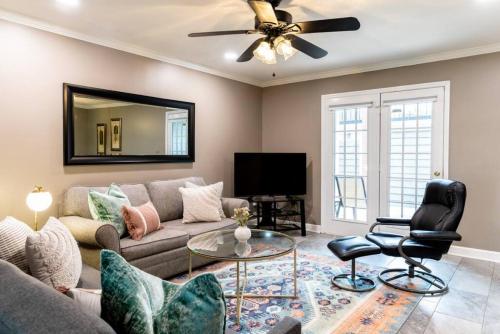 a living room with a couch and a ceiling fan at Downtown Nashville Condo, Walk to Broadway with Free Parking in Nashville