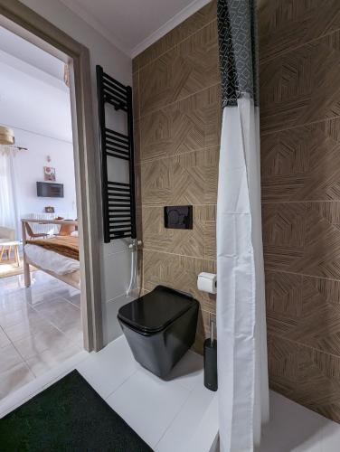 a bathroom with a black toilet in a room at The Valkyries 1 in Leonidio
