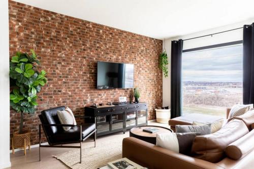 a living room with a brick wall at Stunning River View Condo Walk to Downtown Rooftop Patio in Nashville