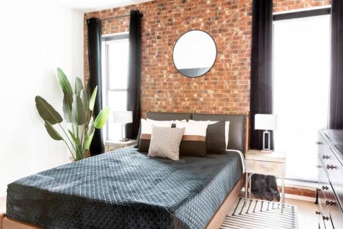 a bedroom with a brick wall and a bed at Stunning River View Condo Walk to Downtown Rooftop Patio in Nashville