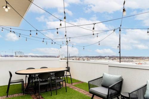 a patio with a table and chairs on a roof at Stunning River View Condo Walk to Downtown Rooftop Patio in Nashville