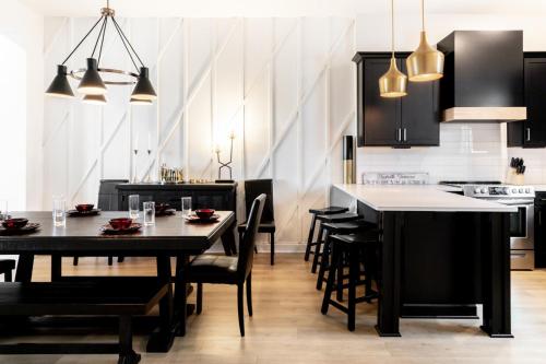 a kitchen with black cabinets and black tables and chairs at Diamond Retreat Townhome 7 Beds 3 mi to Downtown in Nashville