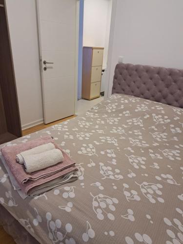 een slaapkamer met een bed met een sprei met witte bloemen bij Sara apartman in Novi Grad