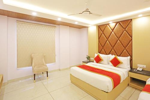 Habitación de hotel con cama y silla en Frankstay By Hotel Mayfair Residency en Nueva Delhi