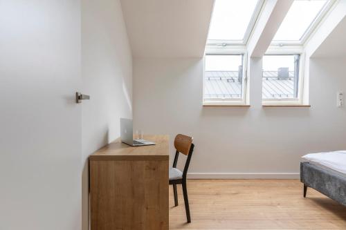 a bedroom with a bed and a desk with a computer on it at Kamienica Parkowa in Dąbki