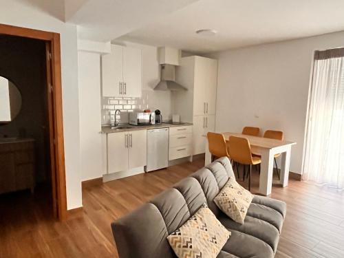 阿奇多納的住宿－Apartamentos EL PELIGRO 5 ZAGUAN，带沙发和桌子的客厅以及厨房。