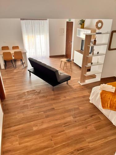 un soggiorno con divano e pavimento in legno di Apartamentos EL PELIGRO 5 ZAGUAN ad Archidona