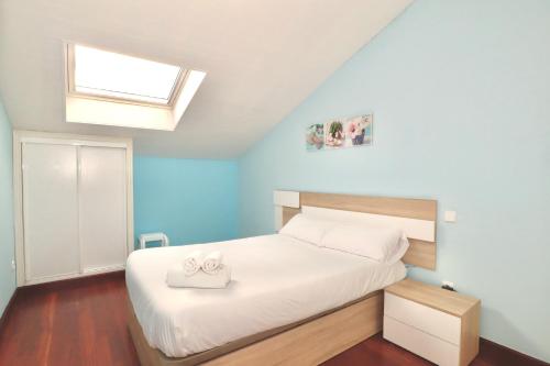 a bedroom with a white bed with a skylight at Casa Rosita in Santander