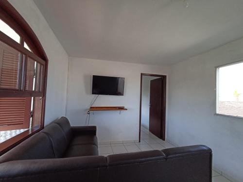 a living room with a couch and a flat screen tv at Sobrado da Ruth in Guaratuba