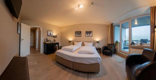 a bedroom with a bed and a large window at Landhotel Flora & Fauna in Winterberg