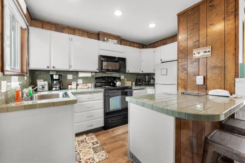 a kitchen with white appliances and wooden cabinets at The Tides by the Sea in Seaside