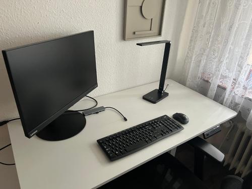 a computer monitor and a keyboard and mouse on a desk at Wohlfühlen nahe Köln-Messe in Cologne