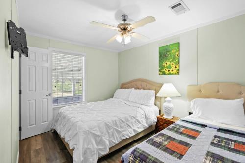 Un dormitorio con dos camas y un ventilador de techo. en Villa Island Retreat, Country house overlooking 13 acres and a small lake, en Saint James City