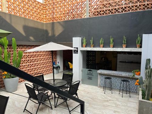 un patio con mesa, sillas y chimenea en Hotel Ciclovía & Terraza en Zitácuaro