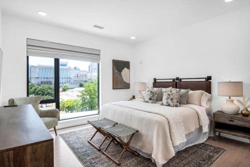 a white bedroom with a bed and a large window at Penthouse River View Walk Downtown, Garage Parking in Nashville