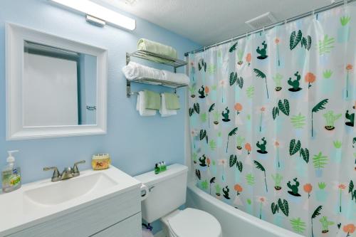 a bathroom with a shower curtain with a toilet and a sink at Corpus Christi Condo with Balcony and Beach Views! in Corpus Christi