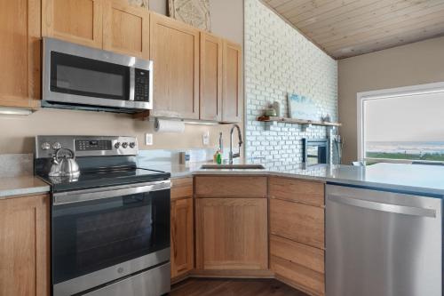 a kitchen with a stove and a microwave at The Tides by the Sea in Seaside