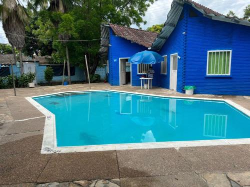 een blauw huis met een zwembad ervoor bij Cabañas Las Gemelas in Melgar