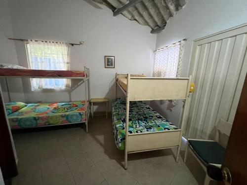 een kamer met 2 stapelbedden en een raam bij Cabañas Las Gemelas in Melgar