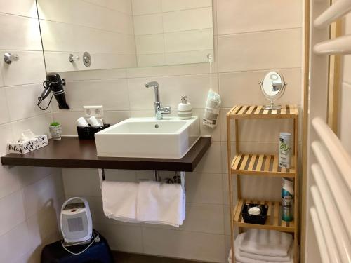 a bathroom with a sink and a shelf with towels at Appartement 51 in Schwäbisch Hall