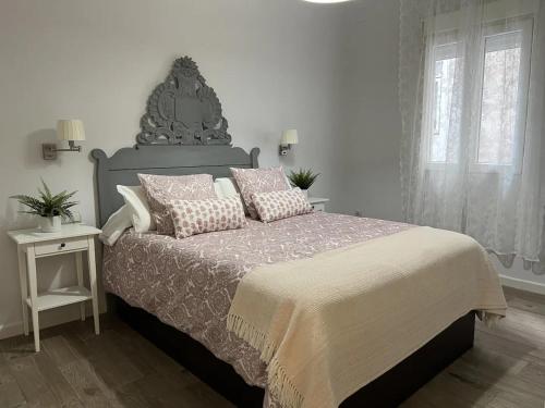 Un dormitorio con una cama grande con almohadas. en Apto LA VICTORIA - céntrico, amplio y Parking gratuito, en Córdoba