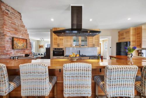 a kitchen with a large wooden counter with chairs at Sugar Maple Farm near Acadia - 5 Bedrooms, 5 Beds with FirePit and Large Deck in Lamoine Corner