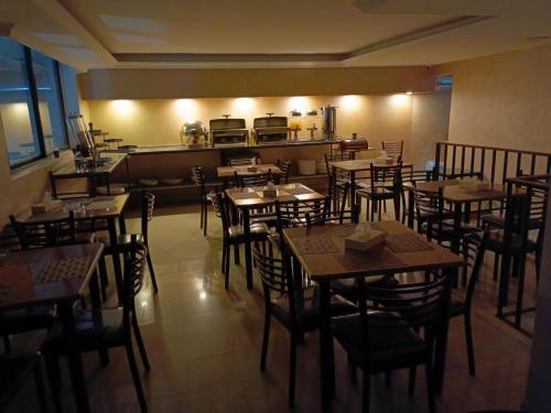 ein Restaurant mit Holztischen und -stühlen und einer Küche in der Unterkunft Al RAYAN HOTEL in Amman