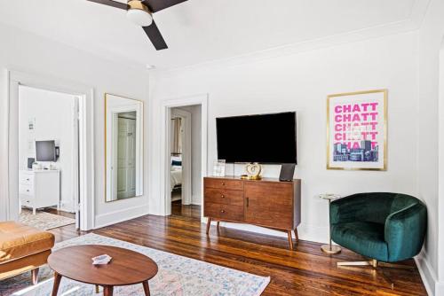 uma sala de estar com uma televisão e uma cadeira verde em Charming House 5 Minutes to Downtown Chattanooga and Aquarium em Chattanooga