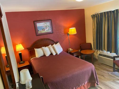 um quarto de hotel com uma cama e uma cadeira em Express Inn em Towson