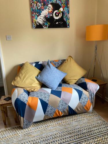 a couch with pillows on it in a living room at Home from Home in our Self-Contained Annexe in Radwinter