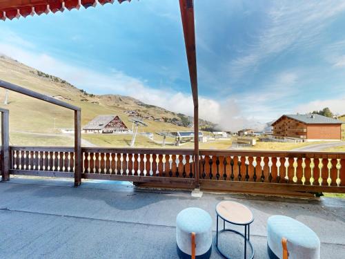 a balcony with two stools and a view of a field at Chalet Montriond in Les Crosets