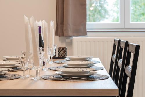 a dining room table with plates and glasses on it at Les Gîtes de Juliane et Eric in Gedinne